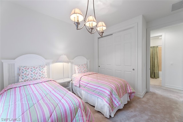 carpeted bedroom featuring an inviting chandelier and a closet