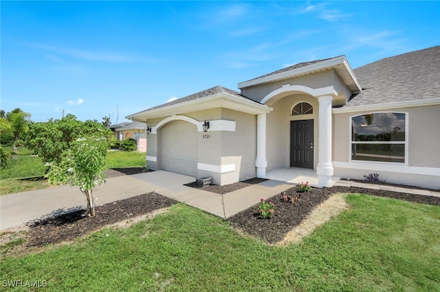 view of front of property with a front yard and a garage