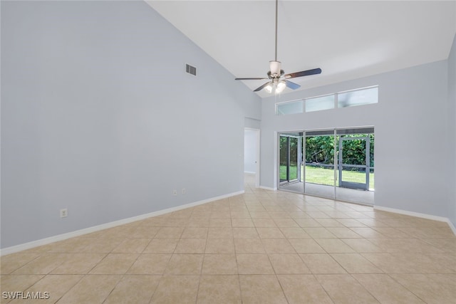 empty room featuring ceiling fan, high vaulted ceiling, and light tile patterned floors