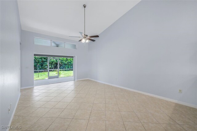 empty room with ceiling fan, high vaulted ceiling, and light tile patterned floors