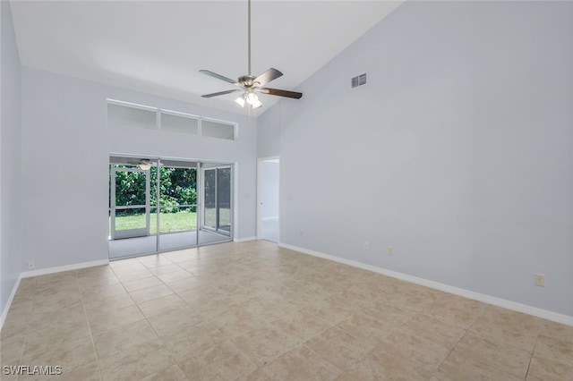 tiled spare room with ceiling fan and high vaulted ceiling