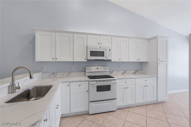 kitchen featuring white cabinetry, sink, light tile patterned floors, and white appliances