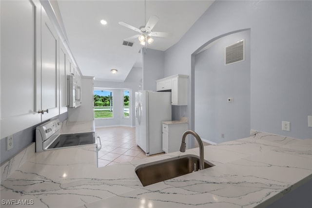 kitchen with sink, white fridge with ice dispenser, light stone countertops, electric stove, and ceiling fan