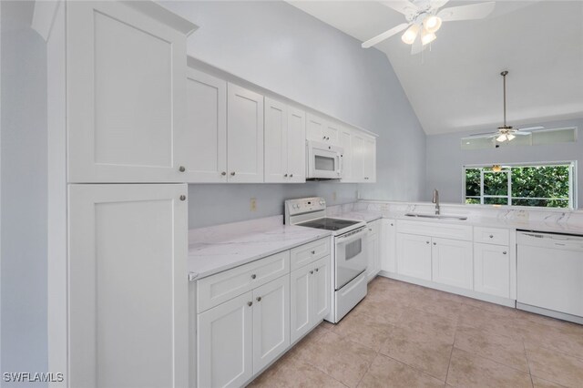 kitchen featuring ceiling fan, lofted ceiling, sink, light tile patterned flooring, and white appliances