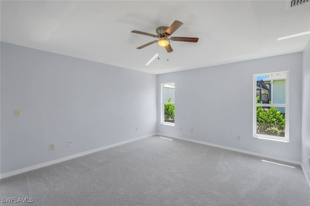 carpeted spare room with plenty of natural light and ceiling fan