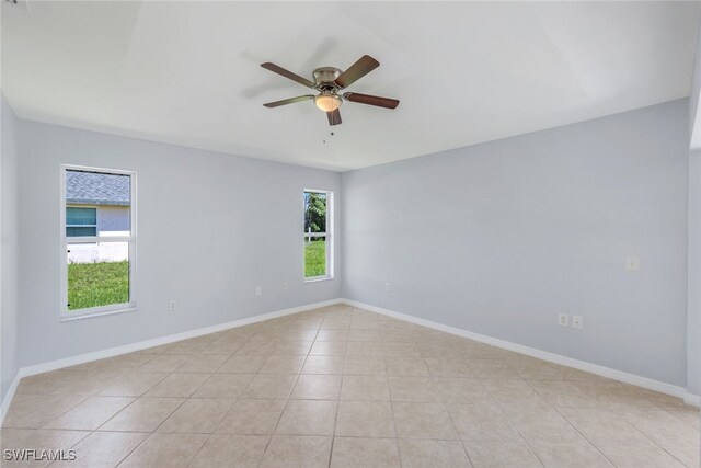 tiled empty room featuring ceiling fan and a healthy amount of sunlight