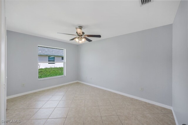 empty room with ceiling fan and light tile patterned floors