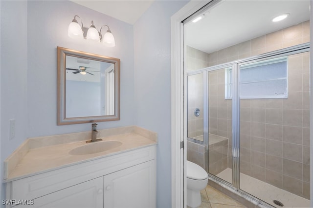 bathroom with ceiling fan, toilet, an enclosed shower, vanity, and tile patterned floors