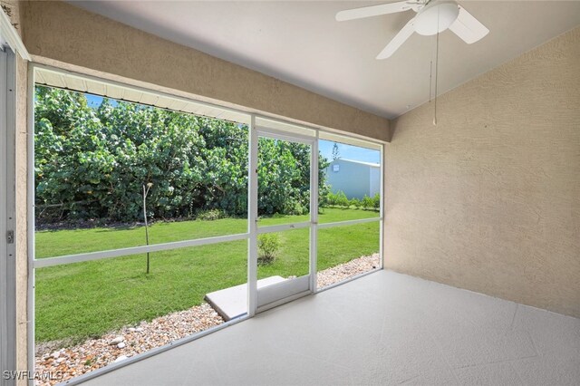 unfurnished sunroom with ceiling fan