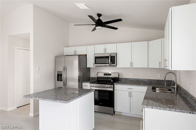 kitchen featuring dark stone countertops, a center island, sink, appliances with stainless steel finishes, and white cabinets