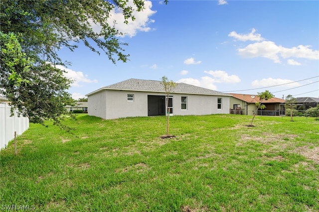 back of house featuring a lawn