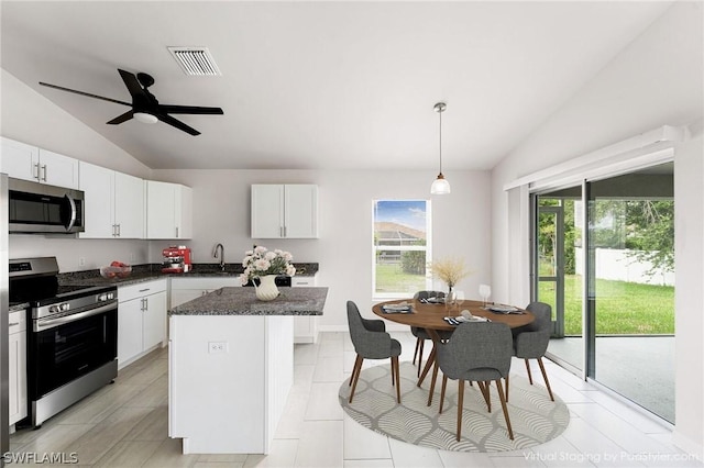 kitchen featuring appliances with stainless steel finishes, white cabinets, and a kitchen island