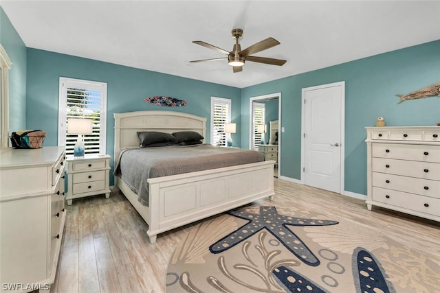 bedroom featuring light wood finished floors, a ceiling fan, and baseboards