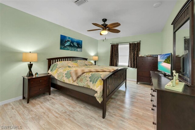 bedroom featuring light wood-type flooring, visible vents, and baseboards