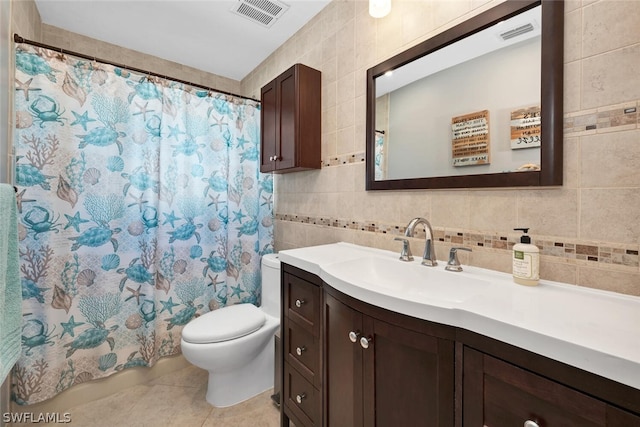 full bathroom featuring visible vents, toilet, tile patterned floors, vanity, and tile walls