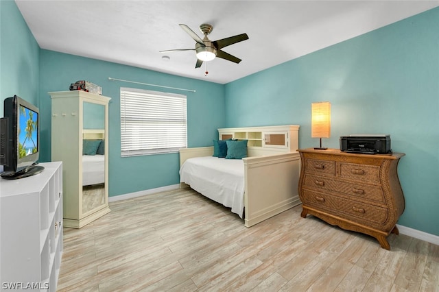 bedroom featuring a ceiling fan, light wood-type flooring, and baseboards