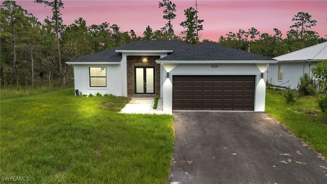 view of front of home featuring a garage and a yard