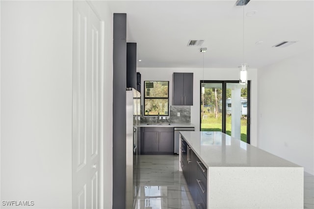 kitchen with decorative backsplash, sink, pendant lighting, dishwasher, and a kitchen island