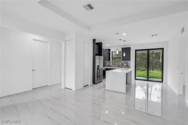 kitchen with stainless steel fridge with ice dispenser, a center island, and backsplash