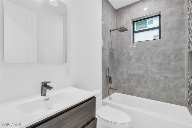 full bathroom with tiled shower / bath, vanity, and toilet