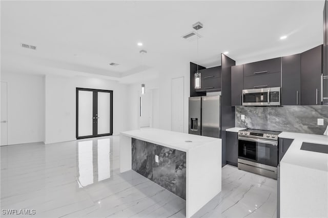 kitchen with a center island, french doors, hanging light fixtures, decorative backsplash, and stainless steel appliances