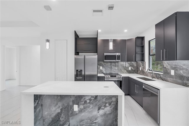 kitchen with backsplash, stainless steel appliances, sink, a kitchen island, and hanging light fixtures