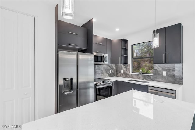 kitchen with appliances with stainless steel finishes, decorative light fixtures, tasteful backsplash, and sink