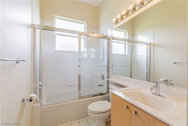 full bathroom featuring vanity, tile patterned flooring, shower / bath combination with glass door, and toilet