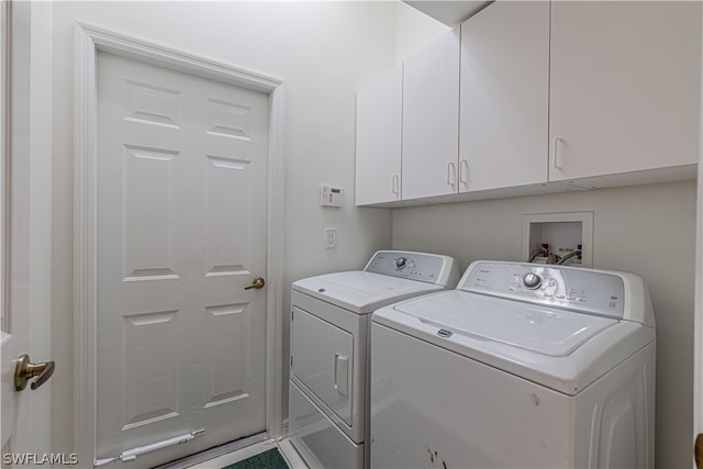 washroom with washer and clothes dryer and cabinets