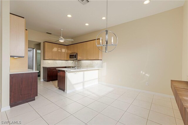 kitchen with decorative light fixtures, ceiling fan with notable chandelier, kitchen peninsula, and light tile patterned flooring