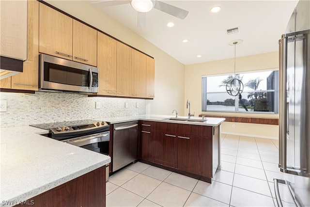 kitchen with decorative light fixtures, ceiling fan, sink, appliances with stainless steel finishes, and backsplash