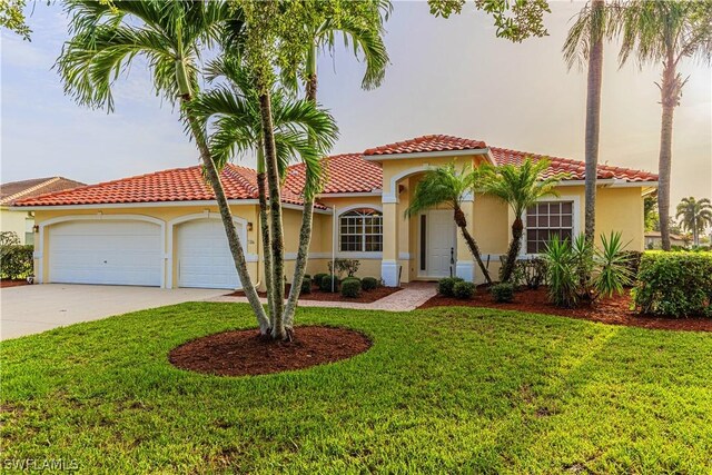 mediterranean / spanish home with a garage and a front yard