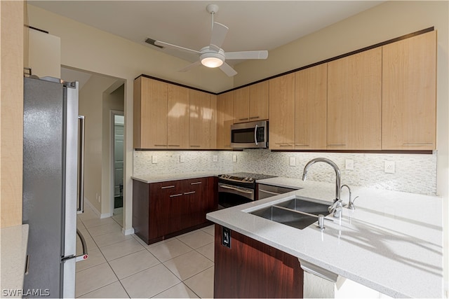 kitchen featuring decorative backsplash, stainless steel appliances, sink, and ceiling fan