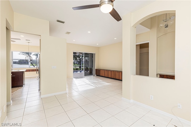 tiled empty room featuring ceiling fan