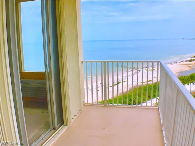 balcony featuring a water view and a beach view