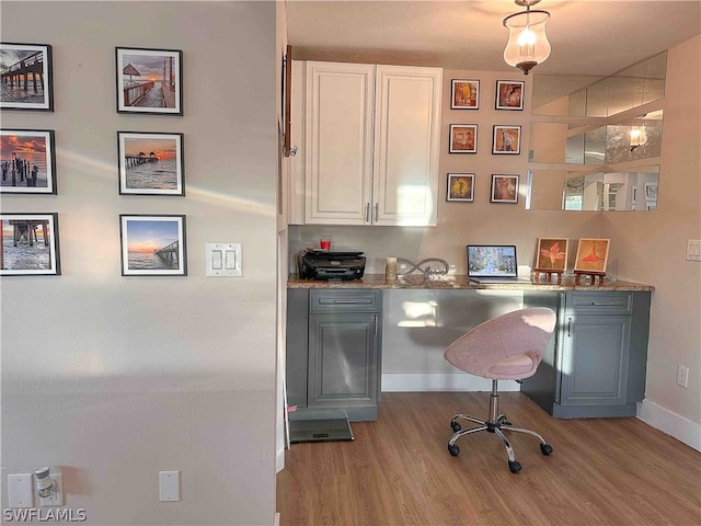 office area with built in desk and light wood-type flooring