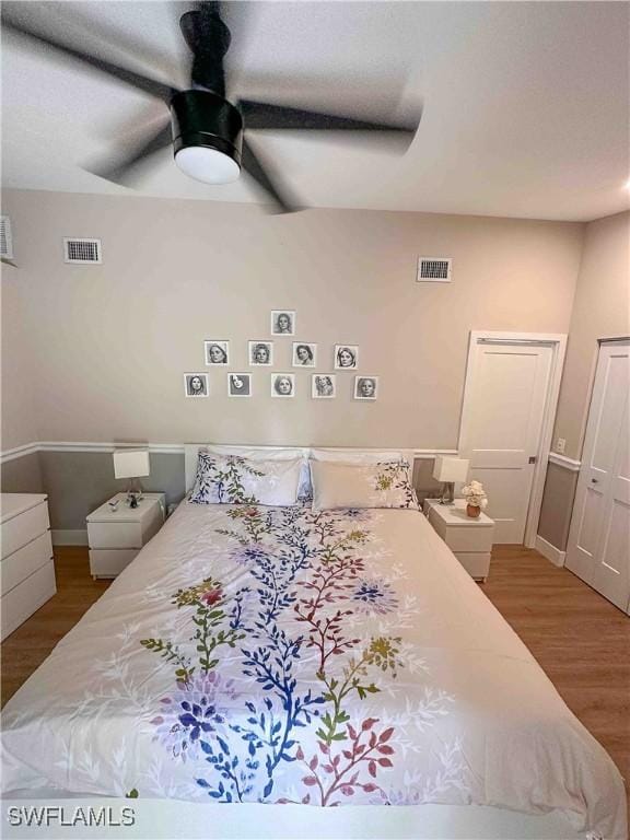 bedroom with visible vents, baseboards, ceiling fan, and wood finished floors