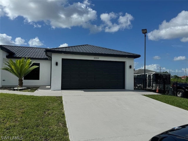 view of front of house featuring a garage and a front lawn