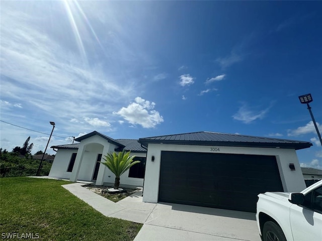 view of front of home with a garage and a front lawn