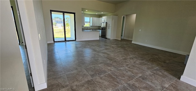 unfurnished living room featuring dark tile patterned floors