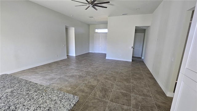 tiled spare room with ceiling fan