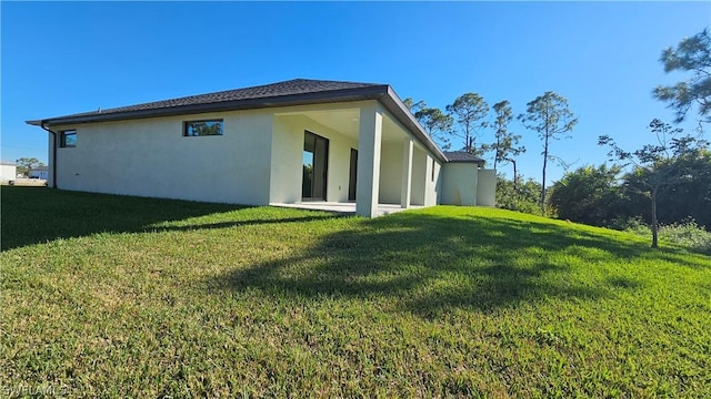 back of property with a patio area and a yard