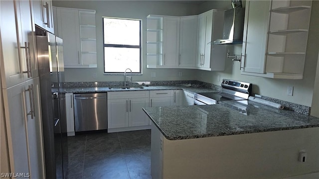 kitchen with kitchen peninsula, stainless steel appliances, wall chimney range hood, sink, and white cabinets