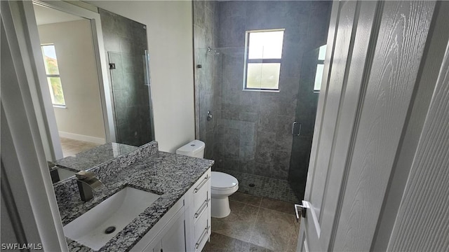 bathroom with tile patterned flooring, vanity, toilet, and walk in shower