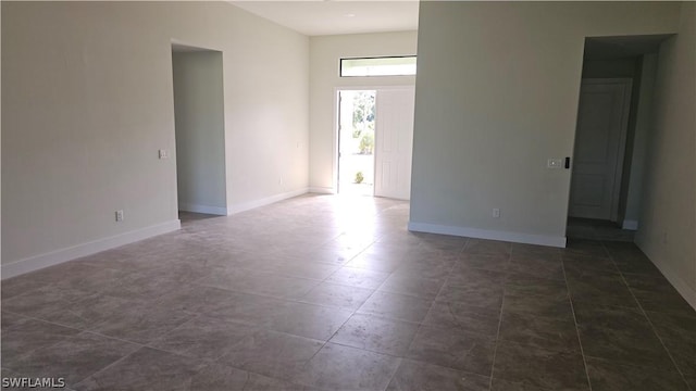 spare room featuring dark tile patterned floors