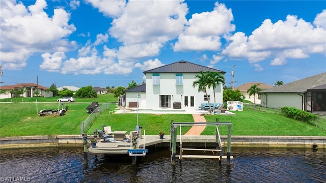 back of house featuring a water view, a balcony, a yard, and a patio area