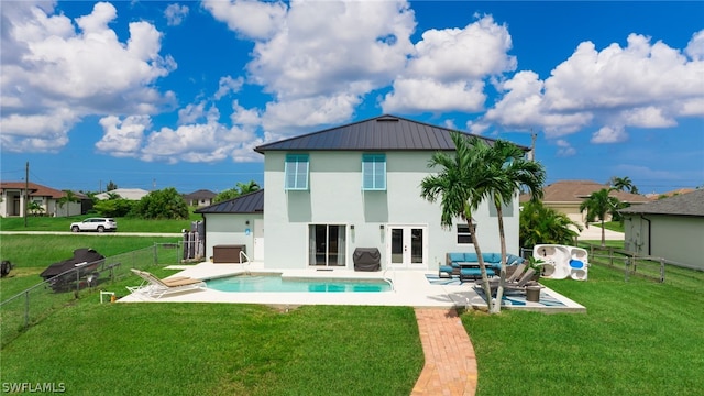 back of house featuring a fenced in pool, a lawn, a patio, and french doors