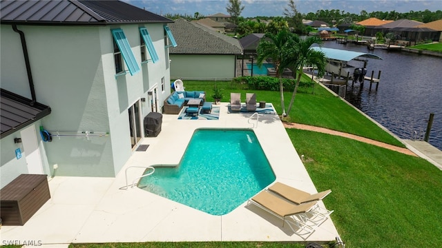 view of pool with an outdoor living space, a patio area, a lawn, and a water view