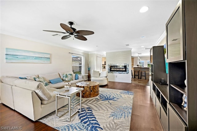 living room featuring hardwood / wood-style flooring, ceiling fan, and ornamental molding