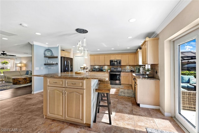 kitchen featuring sink, light brown cabinets, appliances with stainless steel finishes, a kitchen island, and pendant lighting